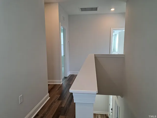 an entryway with wooden floor and stairs