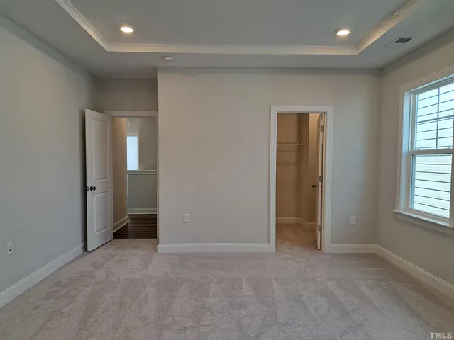 an empty room with windows and closet area
