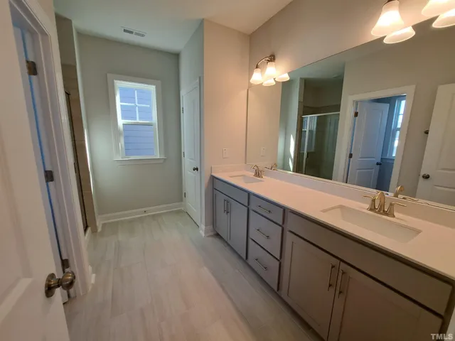 a bathroom with a double vanity sink and mirror