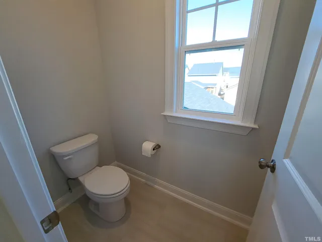 a white toilet sitting in a bathroom next to a window