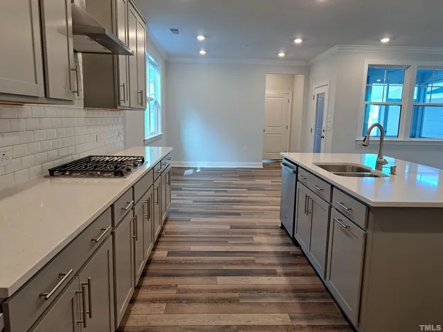 a kitchen with sink stove and cabinets