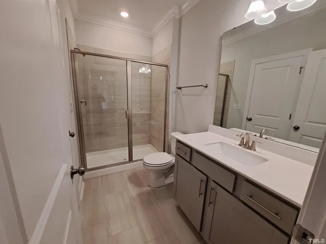 a bathroom with a double vanity sink toilet and shower
