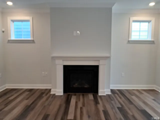 an empty room with wooden floor and fireplace