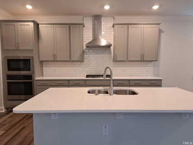 a kitchen with a sink a microwave and cabinets
