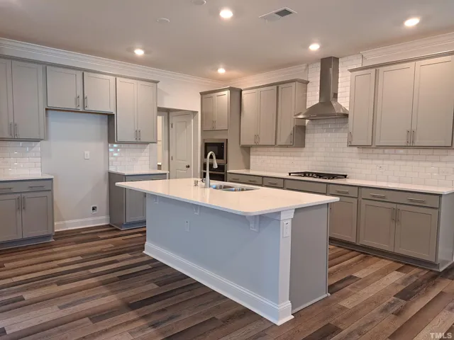a kitchen with kitchen island a sink stainless steel appliances and cabinets