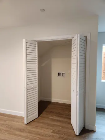 an empty room with wooden floor and closet
