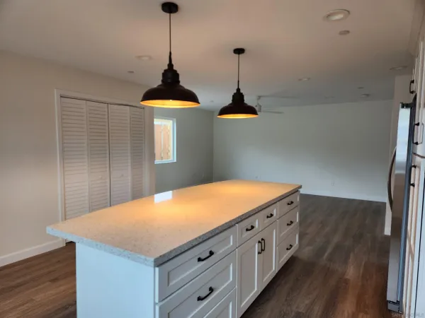 a kitchen with stainless steel appliances granite countertop a sink a stove and wooden floor