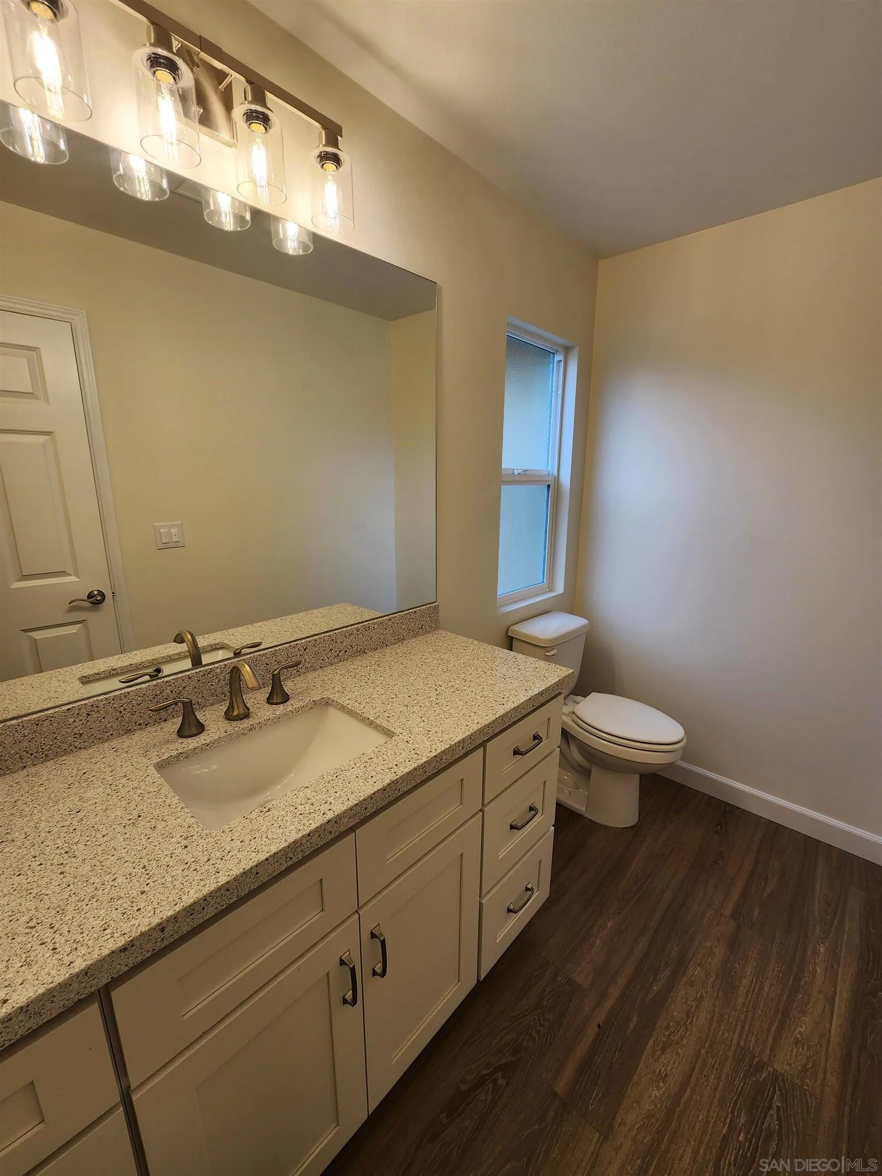750 North Citrus Avenue, Unit 1 Vista, CA 92084 - Photo 3 of 14 a bathroom with a granite countertop sink a toilet and a mirror