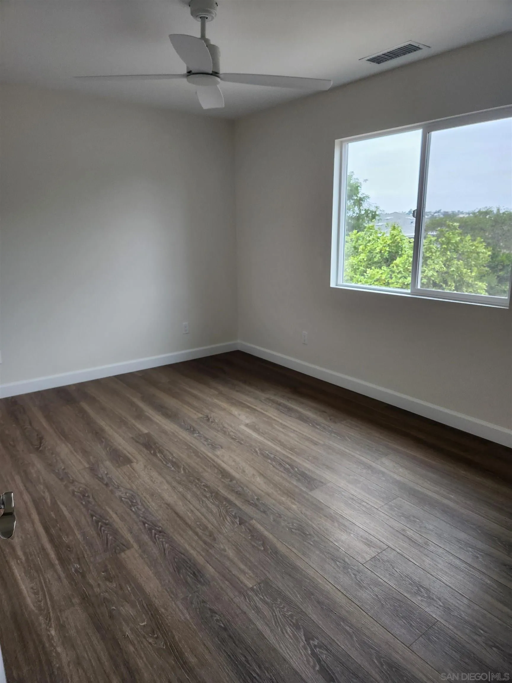 750 North Citrus Avenue, Unit 1 Vista, CA 92084 - Photo 5 of 14 an empty room with wooden floor and windows