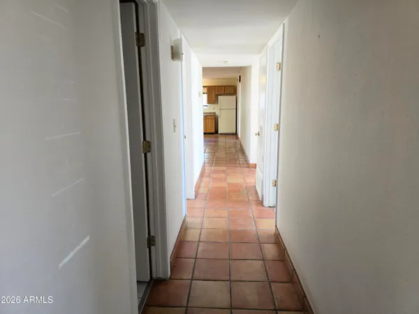 a hallway with a view of a bathroom
