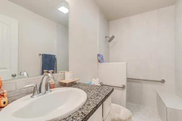 a bathroom with a granite countertop sink and a mirror