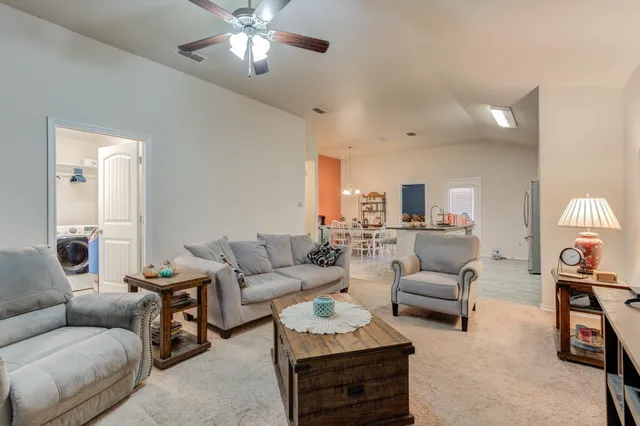 a living room with furniture and a chandelier