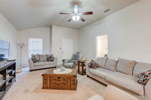 a living room with furniture and a chandelier