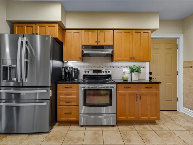 a kitchen with stainless steel appliances granite countertop a refrigerator stove and sink