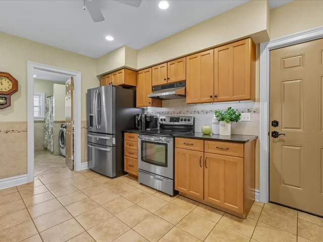 a kitchen with stainless steel appliances granite countertop a refrigerator and a stove top oven
