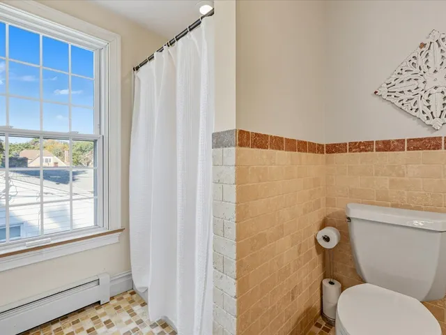 a bathroom with a toilet and a shower curtain