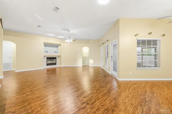 a view of empty room with wooden floor and fireplace