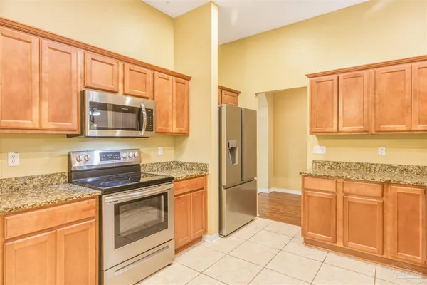 a kitchen with stainless steel appliances granite countertop a stove a sink and a microwave