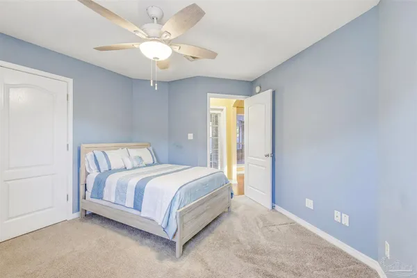 a bed room with a bed and a ceiling fan