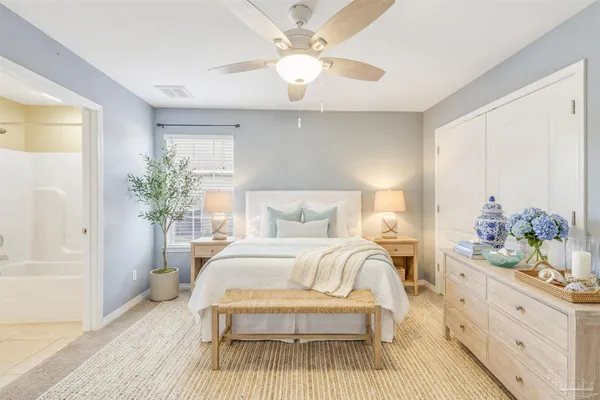 a spacious bedroom with a bed and a chandelier