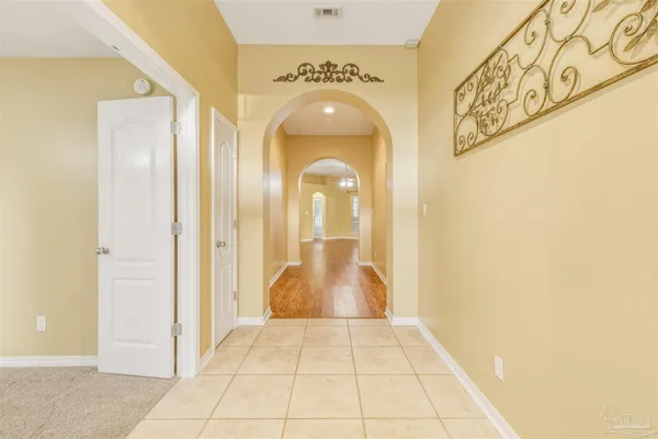 a view of a hallway with wooden floor and a bathroom