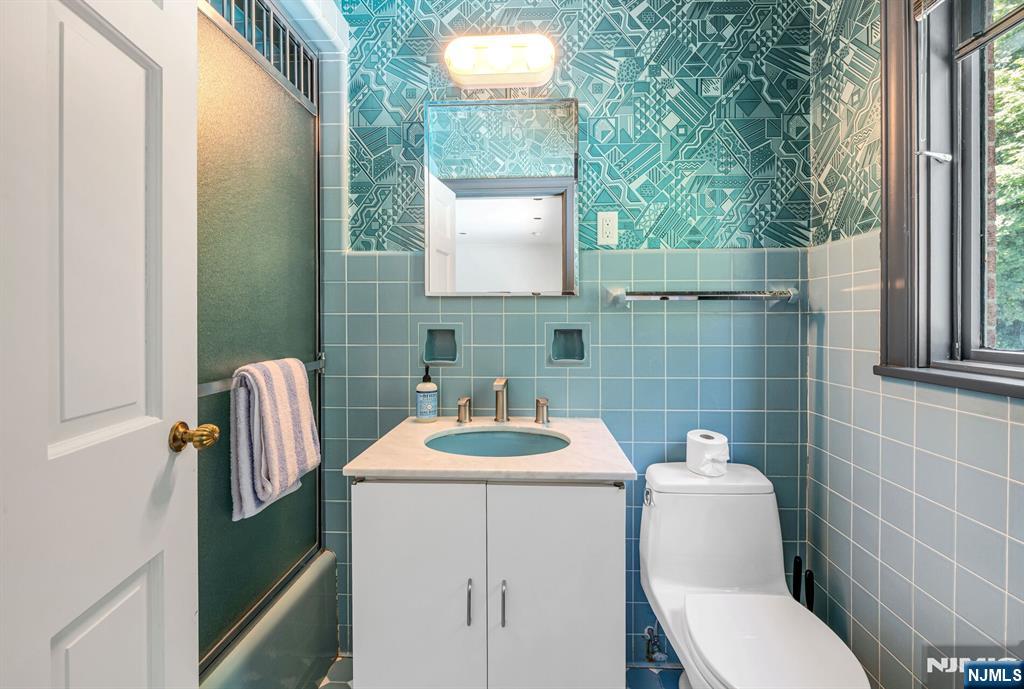 681 Closter Dock Road Closter, NJ 07624 - Photo 24 of 40 a bathroom with a toilet sink and mirror