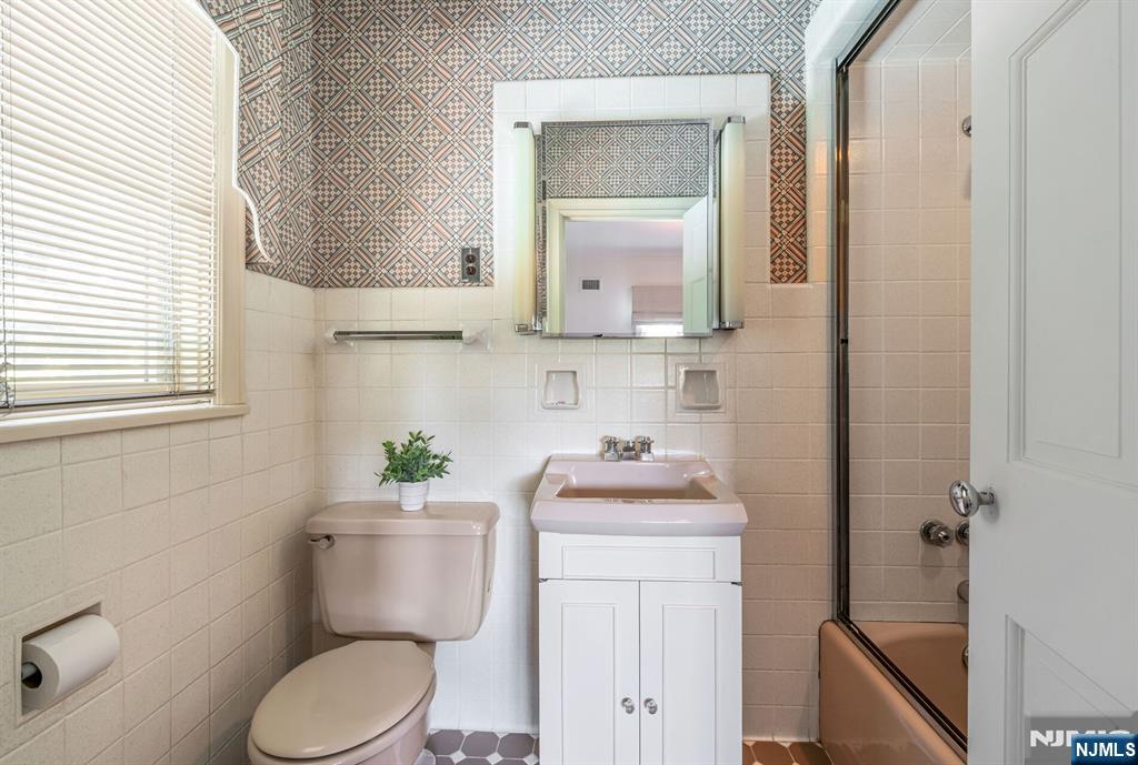 681 Closter Dock Road Closter, NJ 07624 - Photo 30 of 40 a bathroom with a toilet sink vanity and mirror