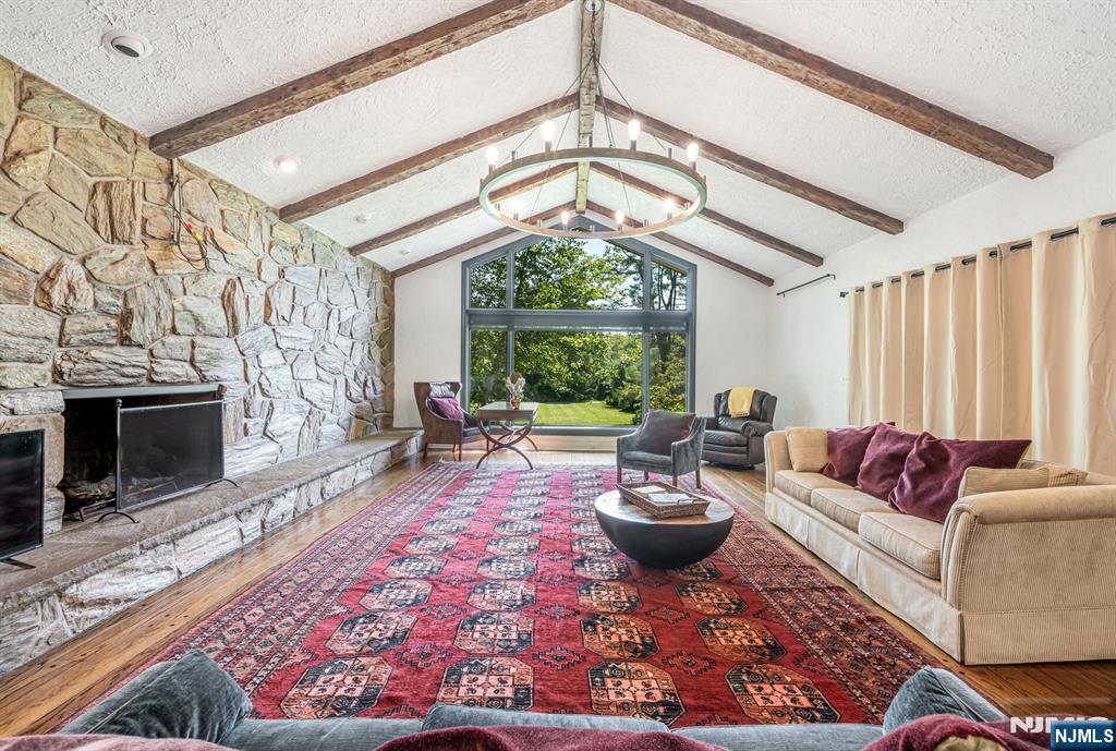 681 Closter Dock Road Closter, NJ 07624 - Photo 7 of 40 a living room with furniture a fireplace and a table