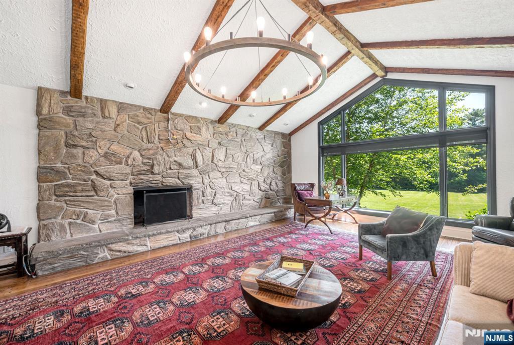 681 Closter Dock Road Closter, NJ 07624 - Photo 8 of 40 a living room with furniture a fireplace and a floor to ceiling window