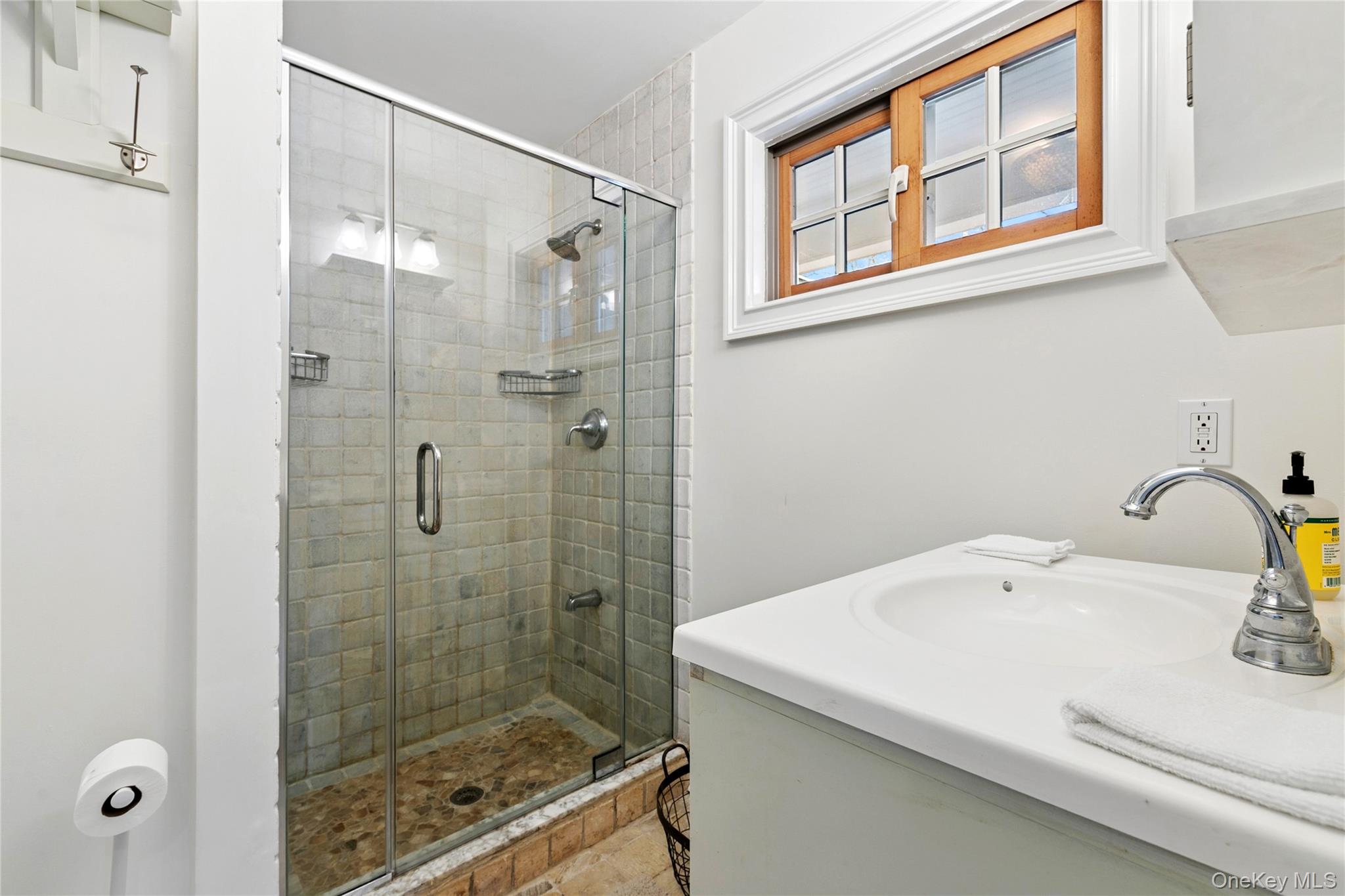 10 Foxboro Road East Quogue, NY 11946 - Photo 23 of 31 a bathroom with a sink a glass door shower and mirror