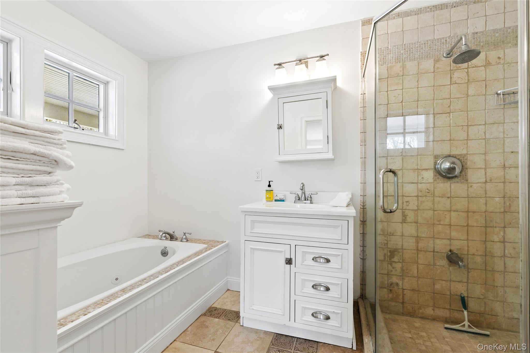 10 Foxboro Road East Quogue, NY 11946 - Photo 26 of 31 a bathroom with a bathtub a sink a vanity and a shower