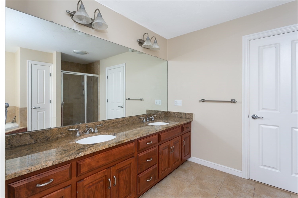 49 Beaver Street, Unit 49 Franklin, MA 02038 - Photo 18 of 46 a bathroom with a granite countertop sink and a mirror