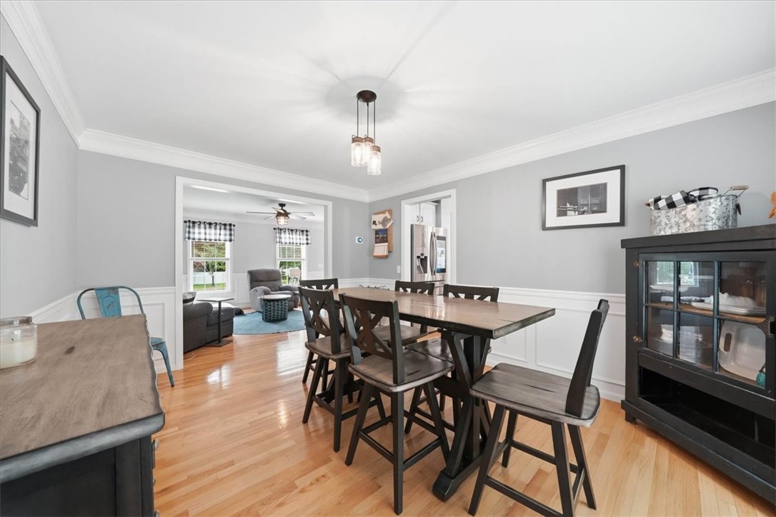 26 Davis Circle Warwick, RI 02886 - Photo 10 of 50 Host with ease in the spacious formal dining room featuring beautiful hardwood floors, decorative molding, large picture windows, and plenty of room for an oversized dining table. Positioned between the kitchen and living room, it provides the perfect setting for seamless entertaining.
