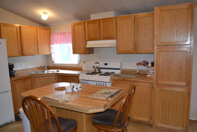 a kitchen with a table chairs refrigerator and cabinets