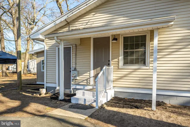 a view of a house with two windows and wooden fence