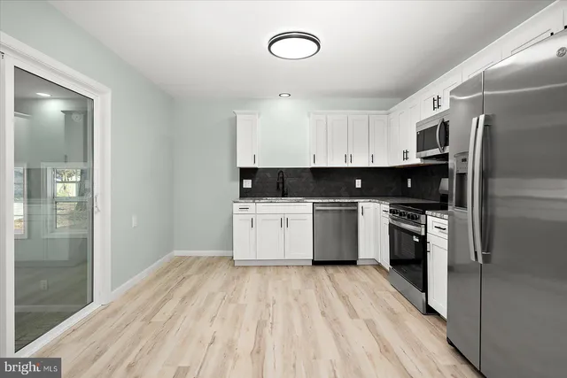 a kitchen with stainless steel appliances a refrigerator sink and cabinets