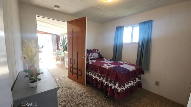 a bed sitting in a bedroom next to a window