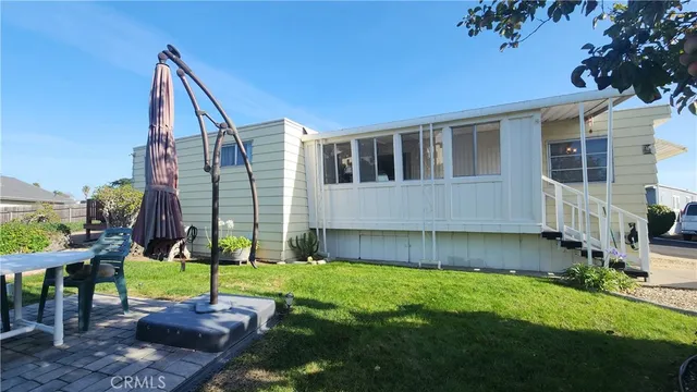 a view of a house with backyard and sitting area