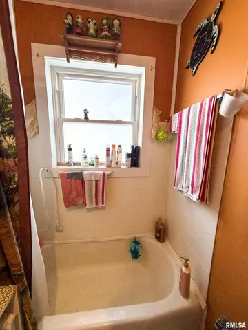 a bathroom with a bathtub sink and mirror