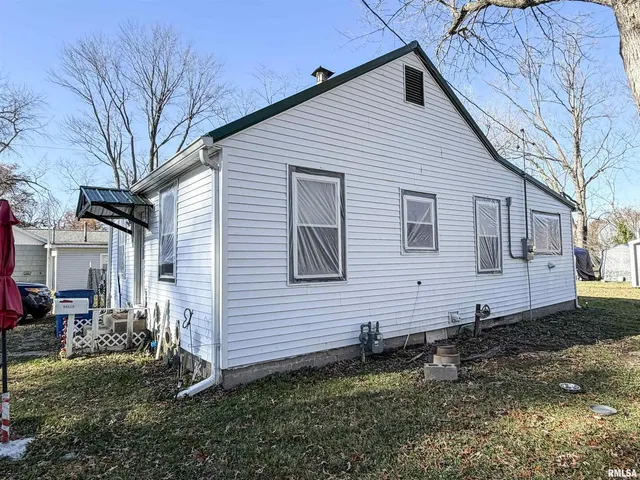 a backyard of a house with fire pit and chairs
