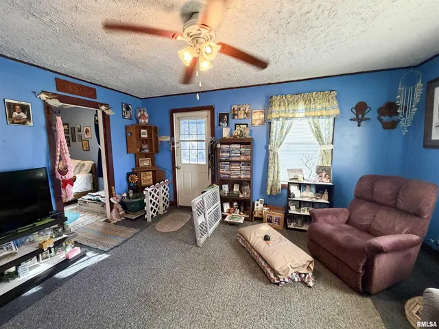 a living room with furniture a flat screen tv and a large window