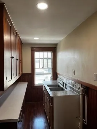 a kitchen with granite countertop stainless steel appliances a sink stove top oven and cabinets