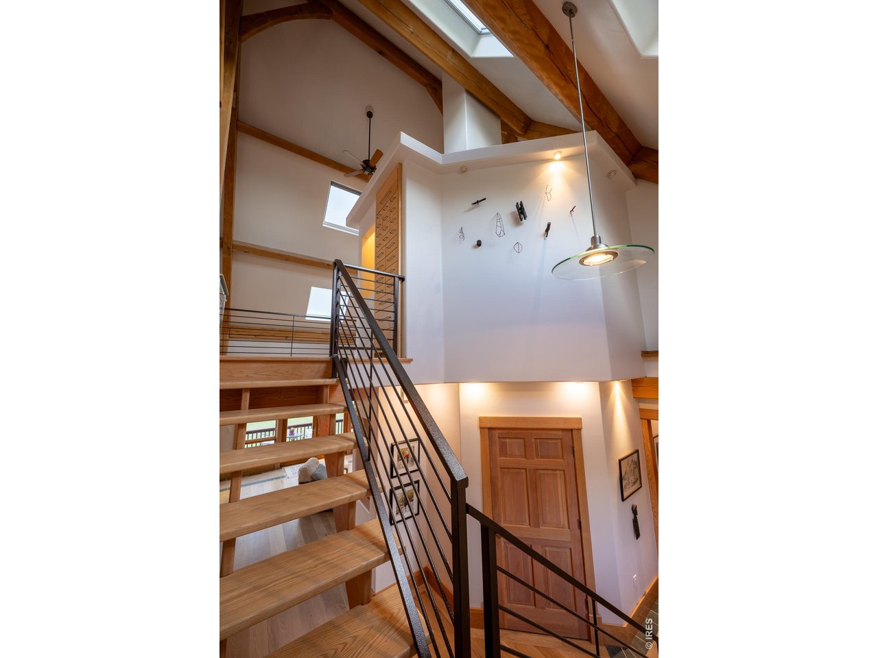 4099 Michaud Lane Fort Collins, CO 80521 - Photo 9 of 50 Ascend the stunning open staircase to the upper level, where you'll find the peaceful primary suite, two additional bedrooms joined by a Jack-and-Jill bath, and a welcoming sitting area overlooking the living and dining spaces below.