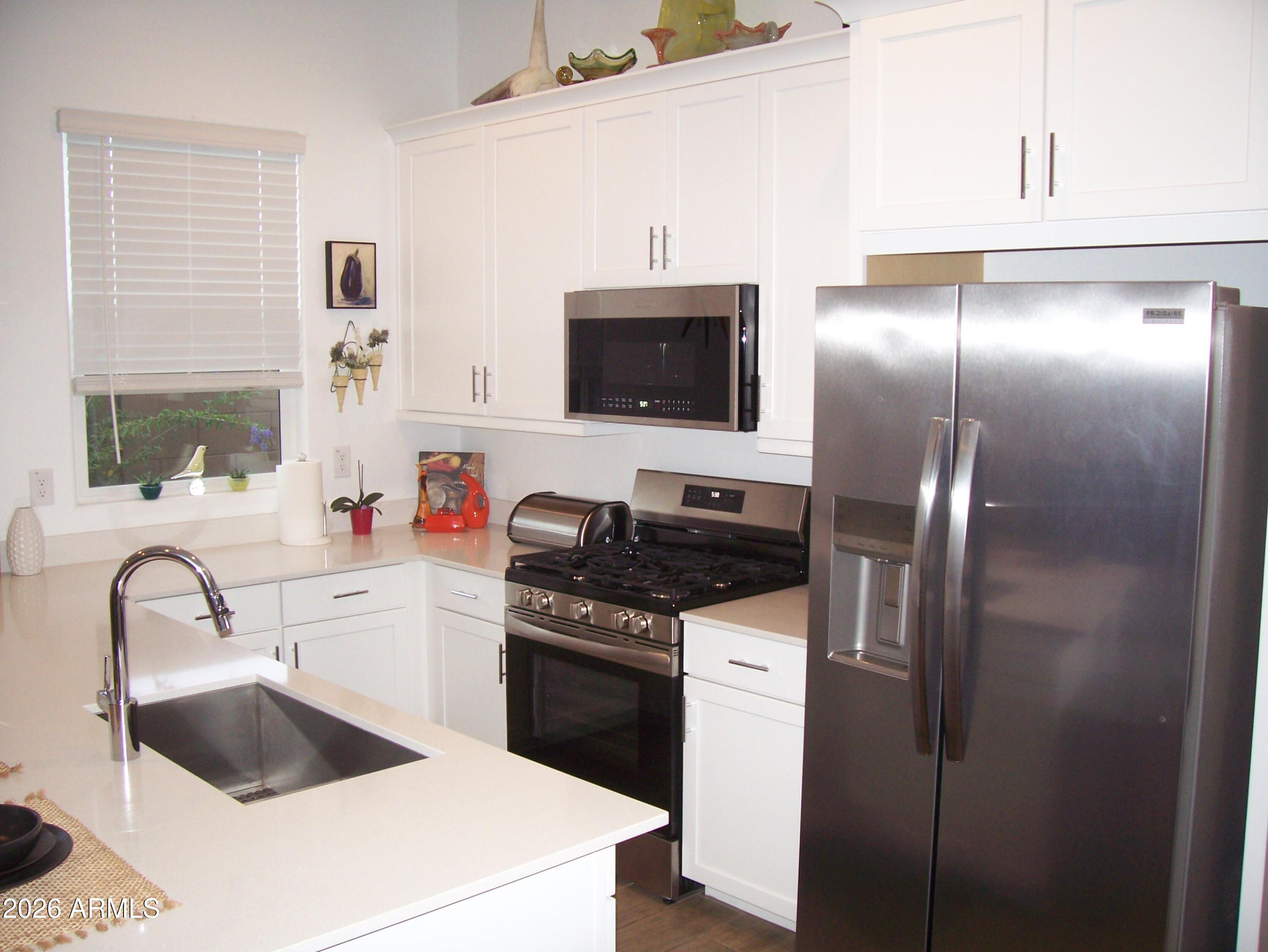 3255 West Peak View Road Phoenix, AZ 85083 - Photo 10 of 46 a kitchen with a sink and a stove top oven with wooden floor