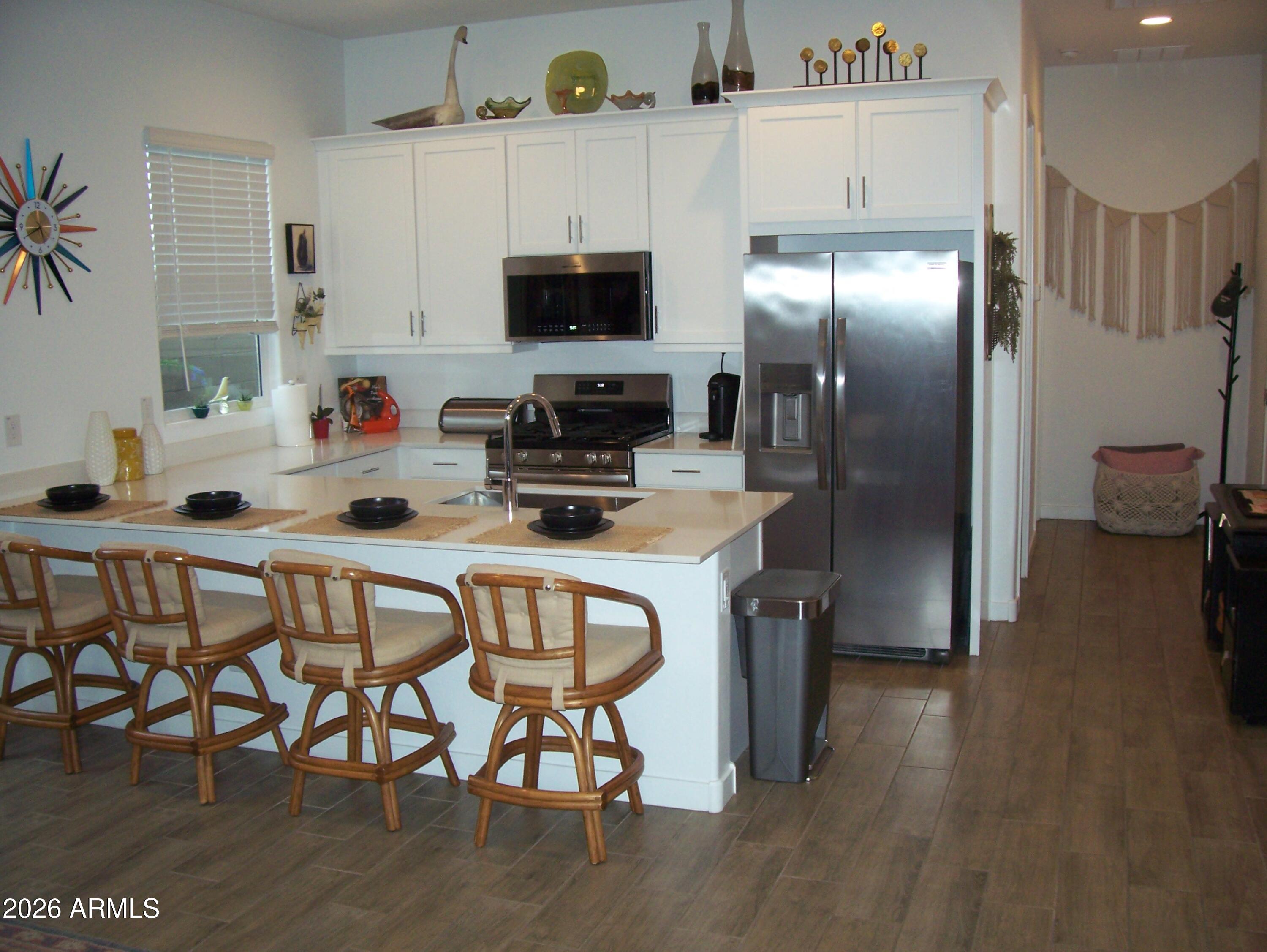 3255 West Peak View Road Phoenix, AZ 85083 - Photo 12 of 46 a kitchen with stainless steel appliances a dining table chairs stove refrigerator and cabinets