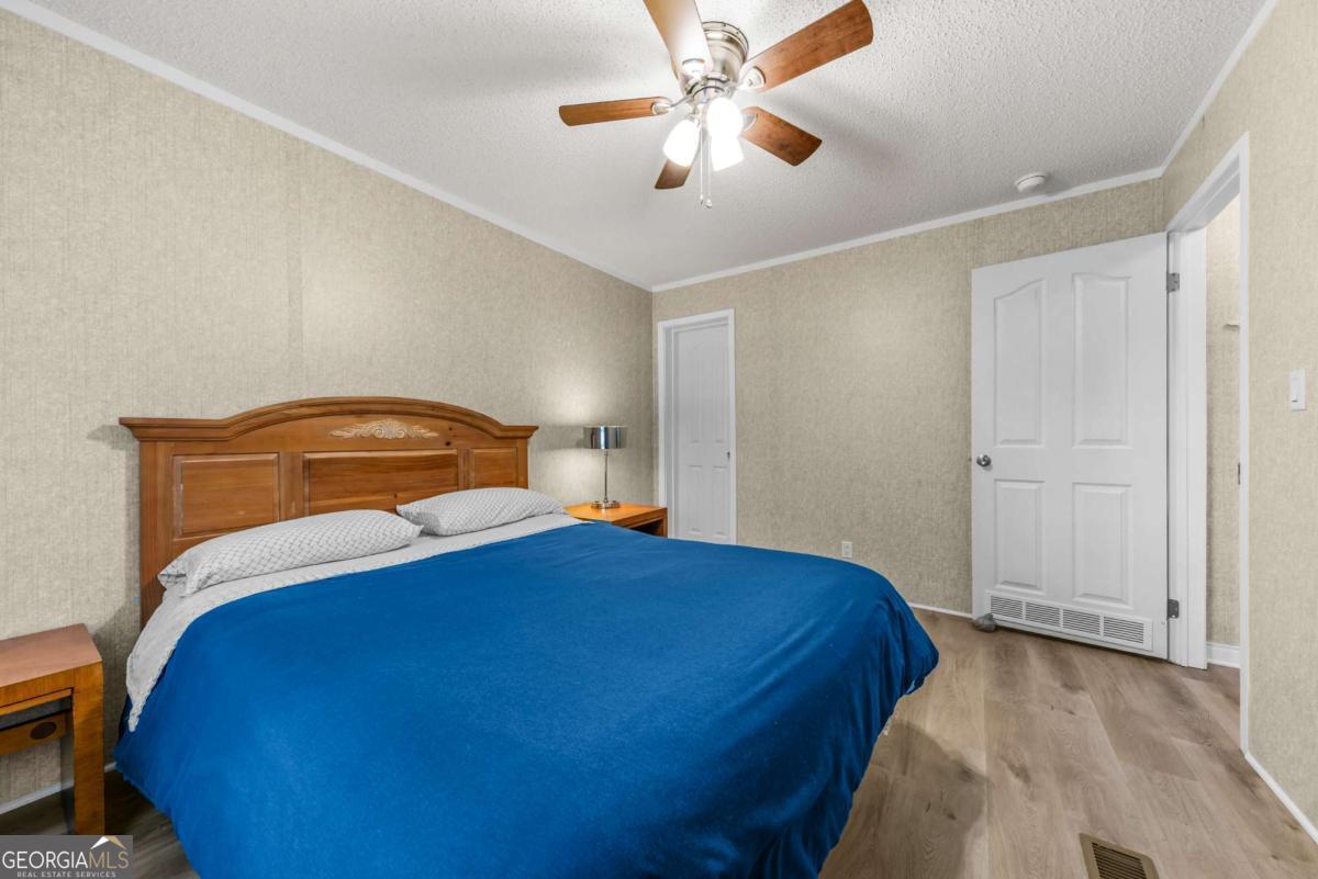 194 Phillips Road Eatonton, GA 31024 - Photo 32 of 57 a bedroom with a bed and a chandelier
