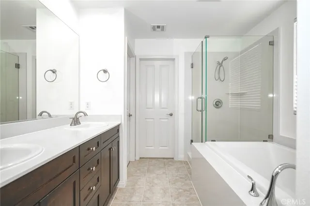 a spacious bathroom with a granite countertop sink a mirror a bathtub and shower