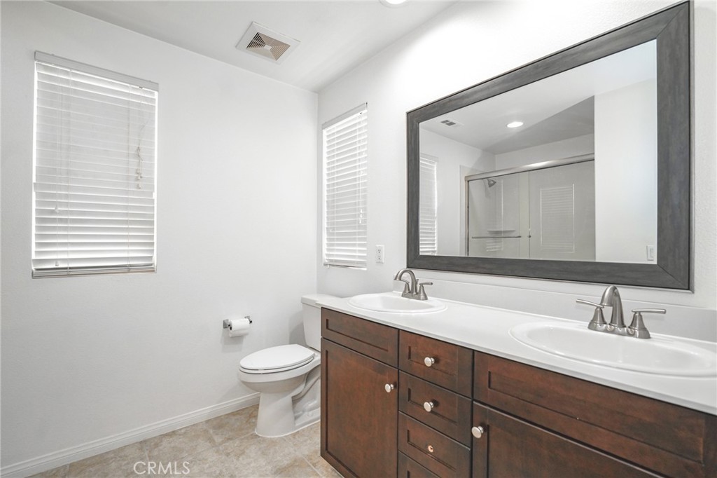 31 Bell Chime Irvine, CA 92618 - Photo 18 of 28 a bathroom with a granite countertop sink a toilet and a mirror