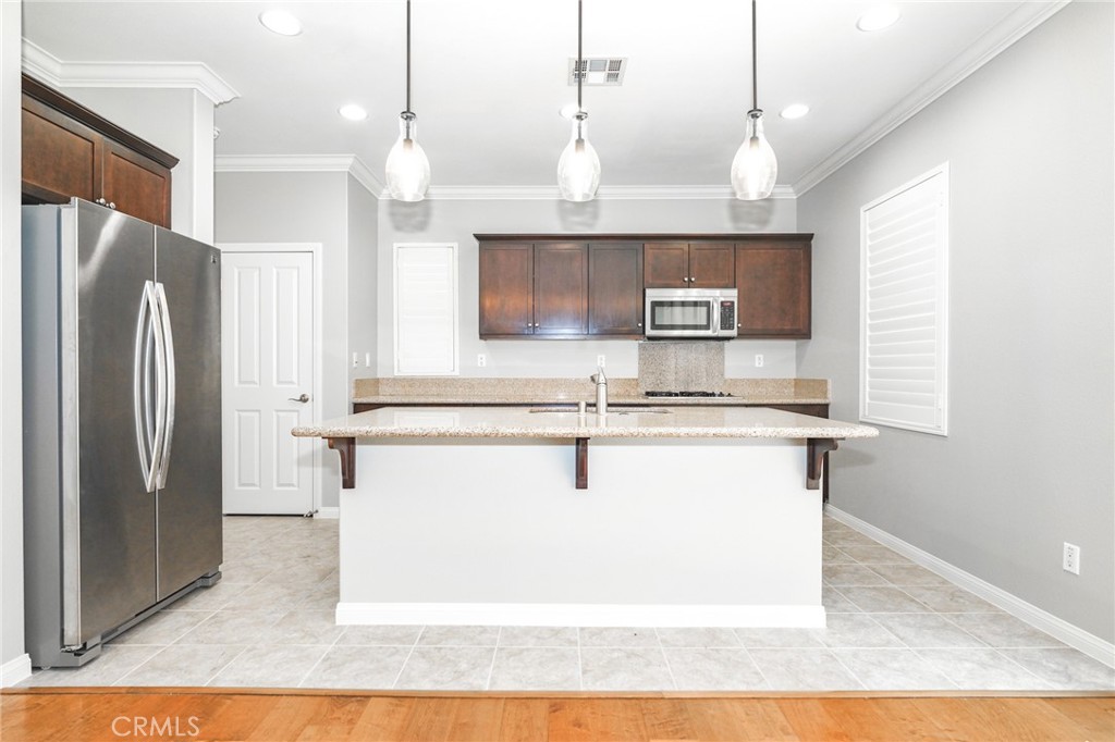 31 Bell Chime Irvine, CA 92618 - Photo 4 of 28 a kitchen with kitchen island a counter top space a sink cabinets and stainless steel appliances