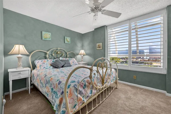 a bathroom with a granite countertop toilet a sink a mirror and shower
